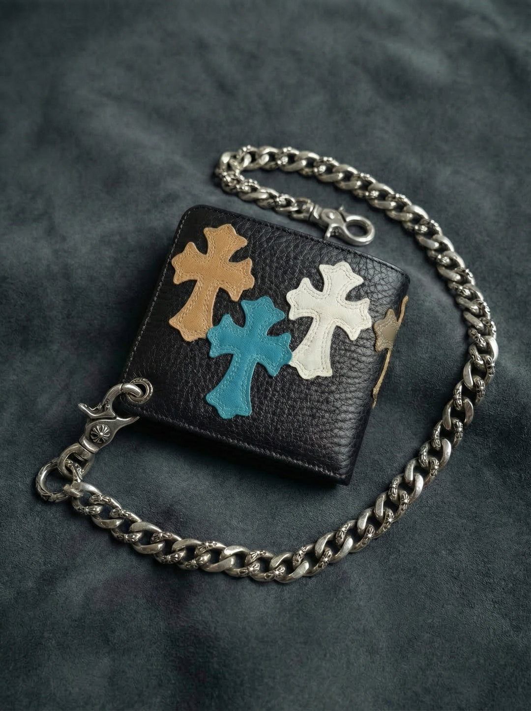 Close-up of a reinforced metal eyelet for a wallet chain on a black gothic cross leather billfold